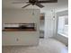 Open-concept living space with ceiling fan, tile floors, and pass-through to kitchen with stainless steel appliances at 1922 Blue Sage Ct, Brandon, FL 33511