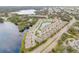 Aerial view of community with lush greenery and a tranquil lake at 1976 Marlington Way, Clearwater, FL 33763