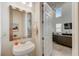 Bright bathroom with white fixtures, large mirror, and open doorway leading to living area at 1976 Marlington Way, Clearwater, FL 33763