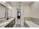 Bright bathroom features double vanity with granite countertops, a soaking tub and a shower at 1976 Marlington Way, Clearwater, FL 33763