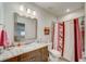 Charming bathroom with a marble countertop, modern lighting, and a decorative shower curtain at 1976 Marlington Way, Clearwater, FL 33763