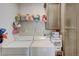 Functional laundry room with washer, dryer, storage shelves, and hanging space at 1976 Marlington Way, Clearwater, FL 33763