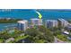 Stunning aerial view showcases waterfront condo buildings, mature trees, and scenic pond at 2 Seaside Ln # 801, Belleair, FL 33756