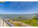 Expansive balcony view featuring lush palm trees and a serene bay, perfect for relaxation at 2 Seaside Ln # 801, Belleair, FL 33756