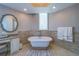 Elegant bathroom featuring a standalone tub, tiled accent wall, vanity, and a stylish decorative mirror at 2 Seaside Ln # 801, Belleair, FL 33756