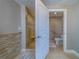 Open door reveals bathroom featuring a tiled walk-in shower with glass and an adjacent toilet with assistive handrail at 2 Seaside Ln # 801, Belleair, FL 33756