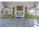 Elegant building entrance with glass doors, lush landscaping, and tile walkway at 2 Seaside Ln # 801, Belleair, FL 33756