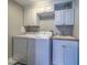 Functional laundry room with white cabinetry, washer, dryer, and sink at 2 Seaside Ln # 801, Belleair, FL 33756