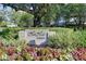 Community sign surrounded by lush landscaping and colorful flowers, creating a welcoming entrance at 2 Seaside Ln # 801, Belleair, FL 33756