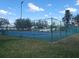 Bright blue tennis court with a green fence on a sunny day at 21544 Clubside Loop, Lutz, FL 33549