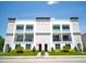Modern three-story building with balconies and well-maintained landscaping under a clear blue sky at 2575 W Platt St, Tampa, FL 33609