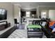 Cozy living room with dark wood floors, a leather sofa, and an open view to the kitchen and dining areas at 2575 W Platt St, Tampa, FL 33609