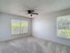 Bright bedroom with neutral carpet, ceiling fan, and two windows providing ample light at 2937 Stilwell Ct, New Port Richey, FL 34655