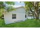 Backyard showcasing the siding, yard and home exterior with a lush lawn and mature trees at 3114 E 21St Ave, Tampa, FL 33605