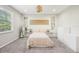 Serene bedroom featuring neutral tones, plush carpet, decorative shelves, and ample natural light from a large window at 3114 E 21St Ave, Tampa, FL 33605