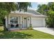 Charming single-Gathering home featuring a two-car garage, welcoming front porch, and manicured lawn at 3114 E 21St Ave, Tampa, FL 33605