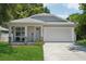 Charming single-Gathering home featuring a two-car garage, welcoming front porch, and manicured lawn at 3114 E 21St Ave, Tampa, FL 33605