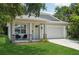 Charming single-Gathering home featuring a two-car garage, welcoming front porch, and manicured lawn at 3114 E 21St Ave, Tampa, FL 33605