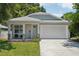Charming single-Gathering home featuring a two-car garage, welcoming front porch, and manicured lawn at 3114 E 21St Ave, Tampa, FL 33605