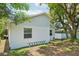 Rear exterior of the home with siding and a ladder, complemented by mature trees at 3114 E 21St Ave, Tampa, FL 33605