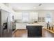 Bright kitchen featuring white cabinets, stainless steel appliances, and a rolling kitchen island for added workspace at 3114 E 21St Ave, Tampa, FL 33605