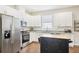 Well-lit kitchen with stainless appliances, granite counters, white cabinets, and a convenient rolling kitchen island at 3114 E 21St Ave, Tampa, FL 33605