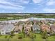 Aerial view of a community of homes with a lake and fountain at 32203 Mahogany Valley Dr, Wesley Chapel, FL 33543