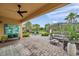 Spacious brick patio featuring ample seating, lush landscaping, and a view of the playground and pergola at 32203 Mahogany Valley Dr, Wesley Chapel, FL 33543