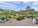 Large backyard featuring a pergola with dining table, a play structure, and mature trees at 32203 Mahogany Valley Dr, Wesley Chapel, FL 33543