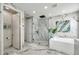 Spacious bathroom with marble walls, glass shower, soaking tub, and elegant fixtures at 32203 Mahogany Valley Dr, Wesley Chapel, FL 33543