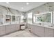Elegant bathroom featuring marble walls, dual sinks, and a vanity area with a faux fur stool at 32203 Mahogany Valley Dr, Wesley Chapel, FL 33543