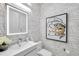 Stylish powder room with modern fixtures, unique wallpaper, and a decorative mirror at 32203 Mahogany Valley Dr, Wesley Chapel, FL 33543