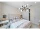 Inviting bedroom with a tufted headboard, patterned wallpaper, and a modern chandelier at 32203 Mahogany Valley Dr, Wesley Chapel, FL 33543