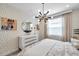Eclectic bedroom with patterned wallpaper, contemporary chandelier, and unique zebra artwork at 32203 Mahogany Valley Dr, Wesley Chapel, FL 33543
