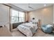 Cozy bedroom featuring a ceiling fan, a large window, and neutral-toned decor at 32203 Mahogany Valley Dr, Wesley Chapel, FL 33543