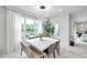 Bright dining room featuring a white table set with views of the landscaped outdoors at 32203 Mahogany Valley Dr, Wesley Chapel, FL 33543