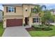 Two-story home with a brick driveway, a two-car garage, and well-maintained landscaping at 32203 Mahogany Valley Dr, Wesley Chapel, FL 33543