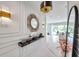 The foyer has white walls with marble floors, a round mirror, and a black console table with decor at 32203 Mahogany Valley Dr, Wesley Chapel, FL 33543