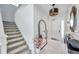 Bright foyer featuring white walls, marble floors, decorative mirror, and staircase at 32203 Mahogany Valley Dr, Wesley Chapel, FL 33543