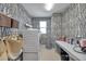 Well-organized laundry room with geometric wallpaper, modern washer/dryer, and ample counter space at 32203 Mahogany Valley Dr, Wesley Chapel, FL 33543