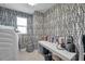 Laundry room features geometric wallpaper, modern washer/dryer, a window and ample counter space at 32203 Mahogany Valley Dr, Wesley Chapel, FL 33543