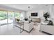Elegant living room featuring marble floors, modern lighting, and access to outdoor patio at 32203 Mahogany Valley Dr, Wesley Chapel, FL 33543