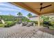 Spacious brick patio featuring ample seating, an outdoor kitchen, and a view of the playground and pergola at 32203 Mahogany Valley Dr, Wesley Chapel, FL 33543