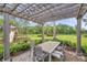 Cozy pergola featuring outdoor seating, string lights, and views of the surrounding greenery and playground at 32203 Mahogany Valley Dr, Wesley Chapel, FL 33543