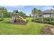Community playground featuring a slide, climbing wall, swings and a nearby pergola with a seating area at 32203 Mahogany Valley Dr, Wesley Chapel, FL 33543