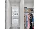 Hallway view from the walk-in closet showcasing the bathroom with marble floors and walls at 32203 Mahogany Valley Dr, Wesley Chapel, FL 33543
