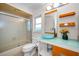 Stylish bathroom with a vessel sink, modern fixtures, orange accents and shower with glass doors at 3411 Glossy Ibis Ct, Palm Harbor, FL 34683