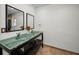 Modern bathroom with glass vessel sinks, dual mirrors, and vanity storage at 3411 Glossy Ibis Ct, Palm Harbor, FL 34683