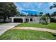 Beautiful single-story home featuring a well-maintained lawn and a dark garage door at 3411 Glossy Ibis Ct, Palm Harbor, FL 34683