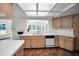 Bright kitchen featuring wood cabinets, tile flooring, and a window overlooking the backyard at 3411 Glossy Ibis Ct, Palm Harbor, FL 34683